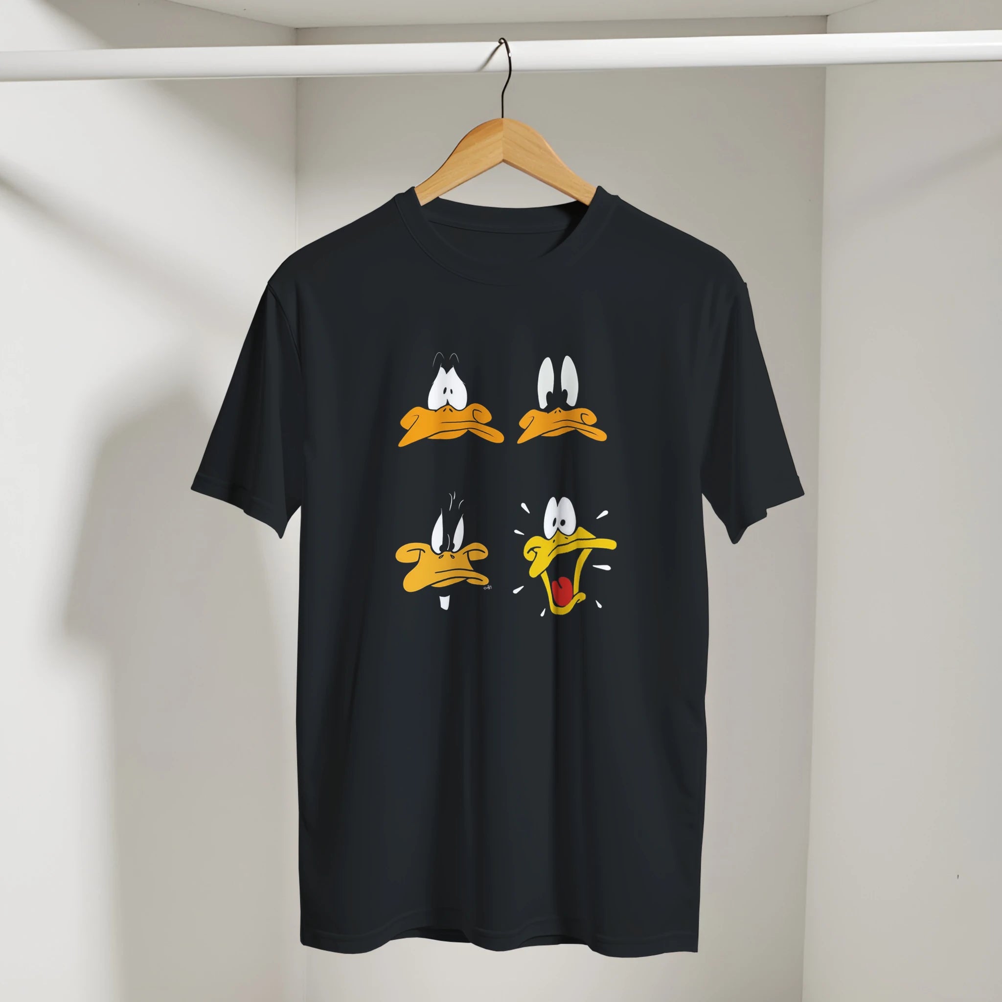 Black t-shirt with cartoon face designs on a hanger against a neutral background