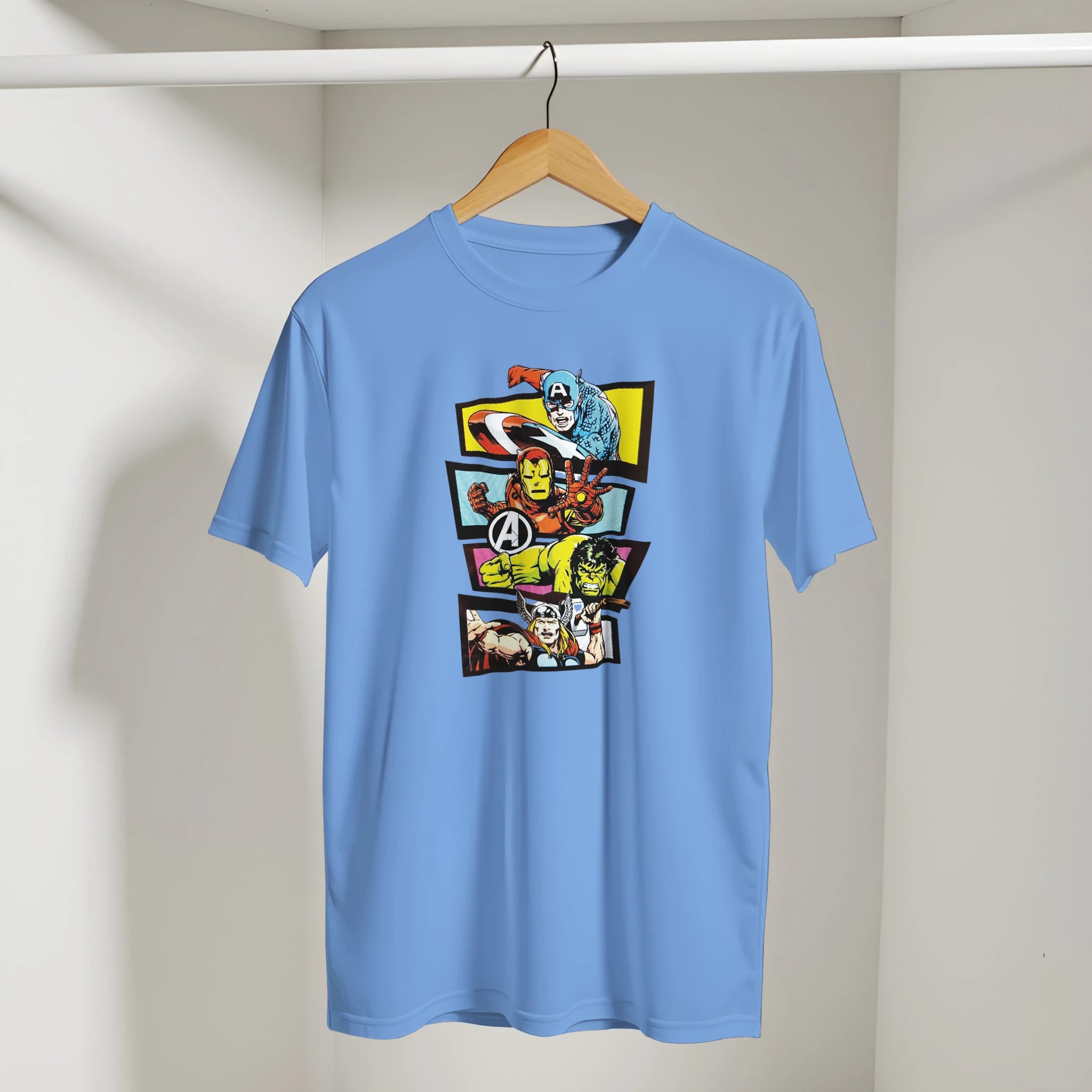 Blue t-shirt with superhero graphic on a hanger against a plain background