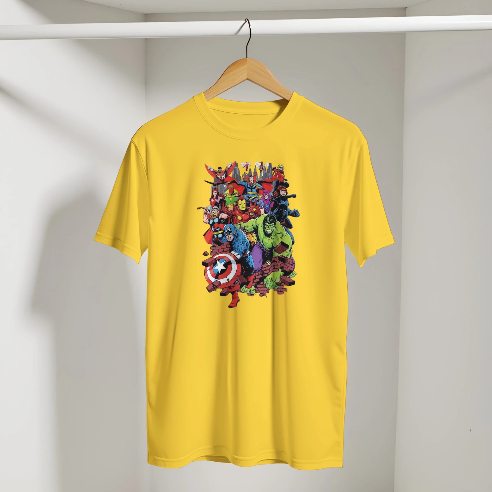 Yellow t-shirt with colorful superhero graphic on a hanger against a plain background